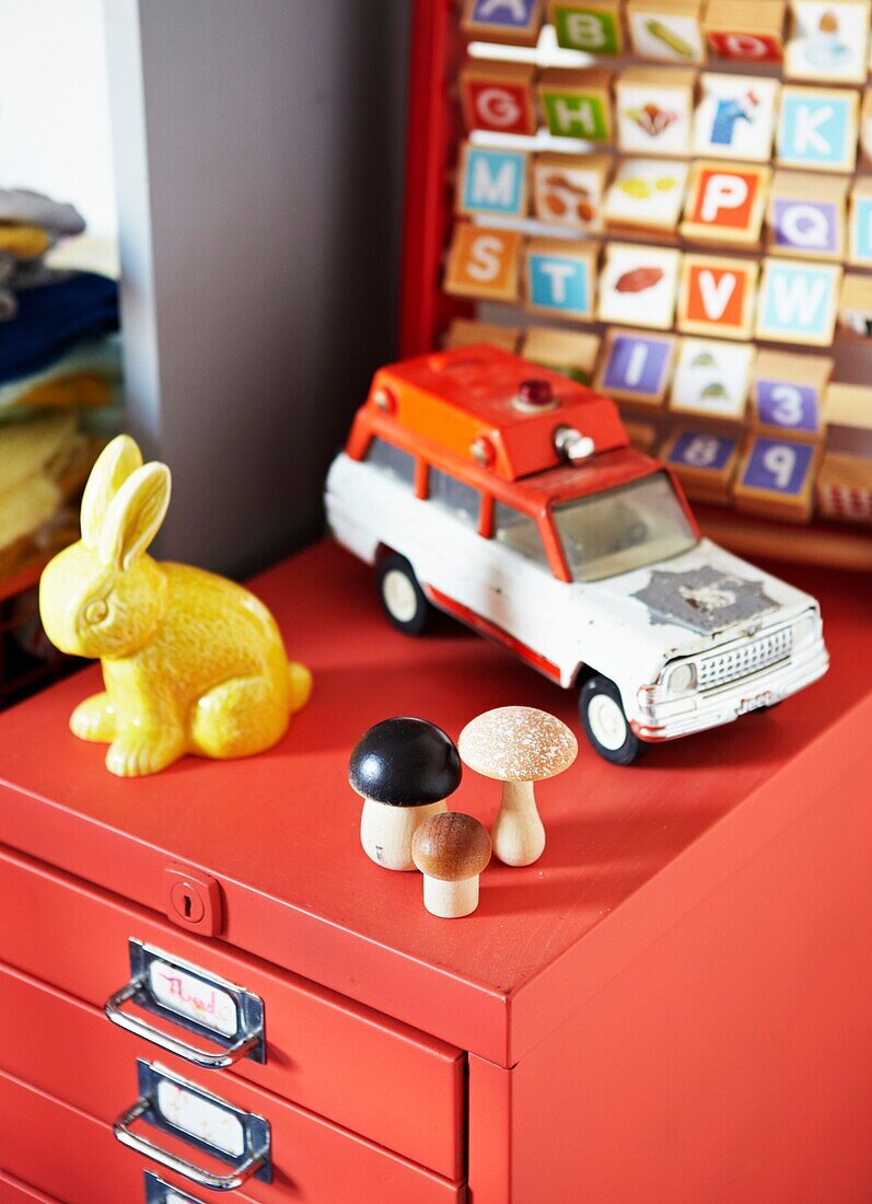 Vintage cat and toy rabbit on red filing cabinet in child's room of London family home,  England,  UK