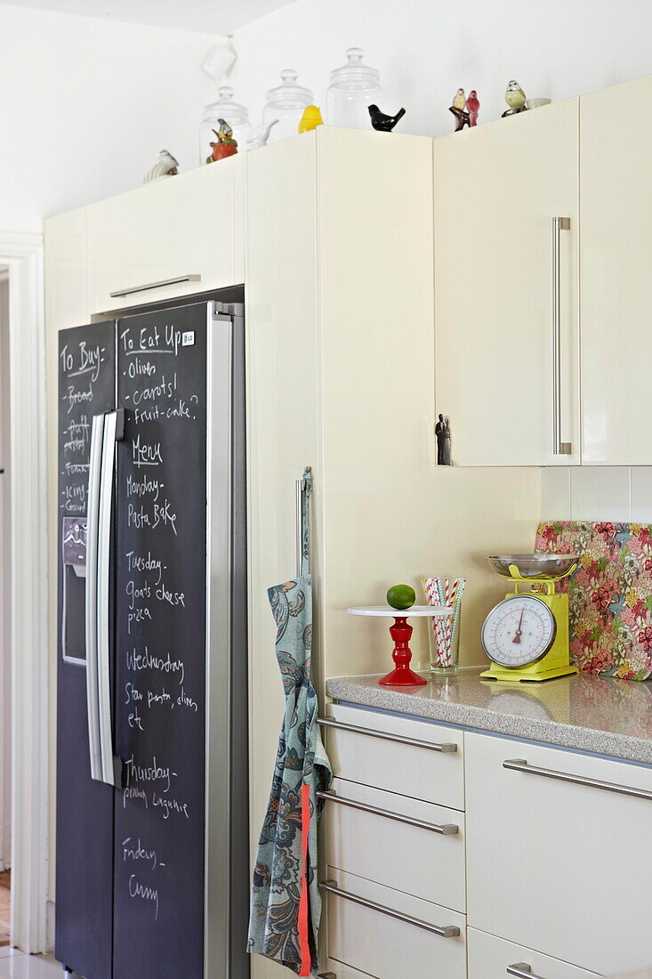 Chalkboard fridge in kitchen of London family home  England  UK