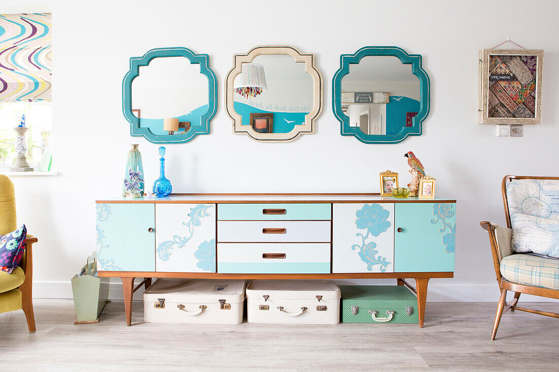 Three mirrors above up-cycled 1970s style sideboard in renovated 1950s coastal beach house West Sussex UK