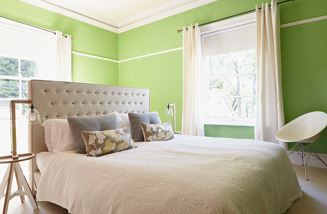 Geknöpftes Kopfteil auf Doppelbett in leuchtendem Grün Londoner Schlafzimmer England UK
