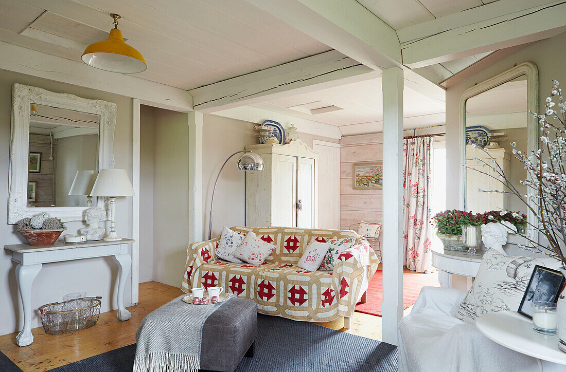 Gemusterte Decke auf Sofa im offenen Wohnzimmer eines britischen Bauernhauses