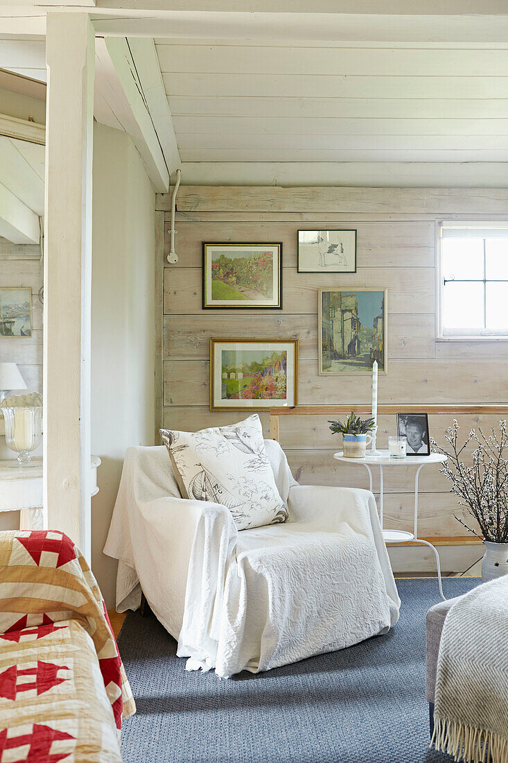 Weiße Decke auf Sessel mit Kunstwerk im Wohnzimmer eines britischen Bauernhauses