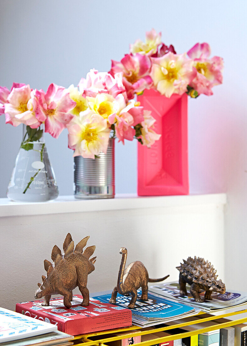 Model dinosaurs with cut flowers in London home,  England,  UK