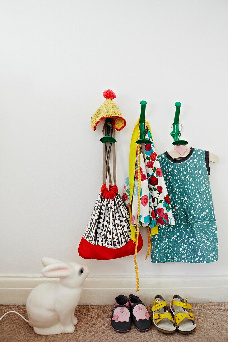 Childrenswear on hooks with ceramic rabbit in London family home  England  UK
