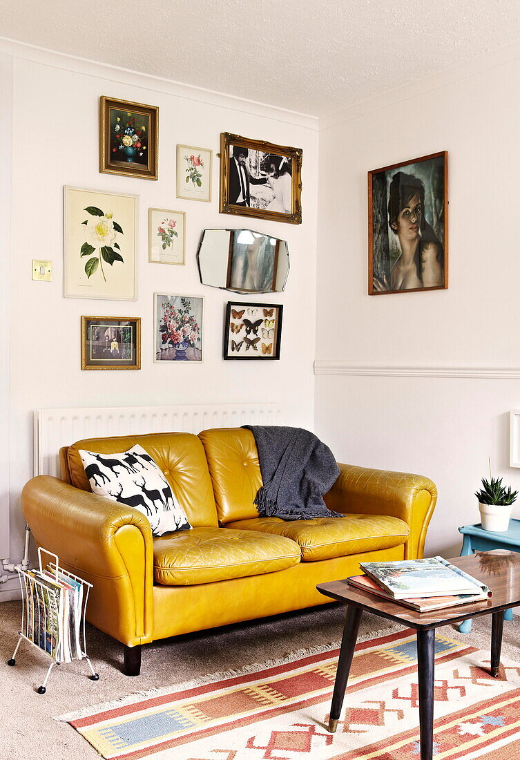 Gelbes Ledersofa im Stil der 1960er Jahre in einer Vintage-Wohnung in Birmingham, England UK