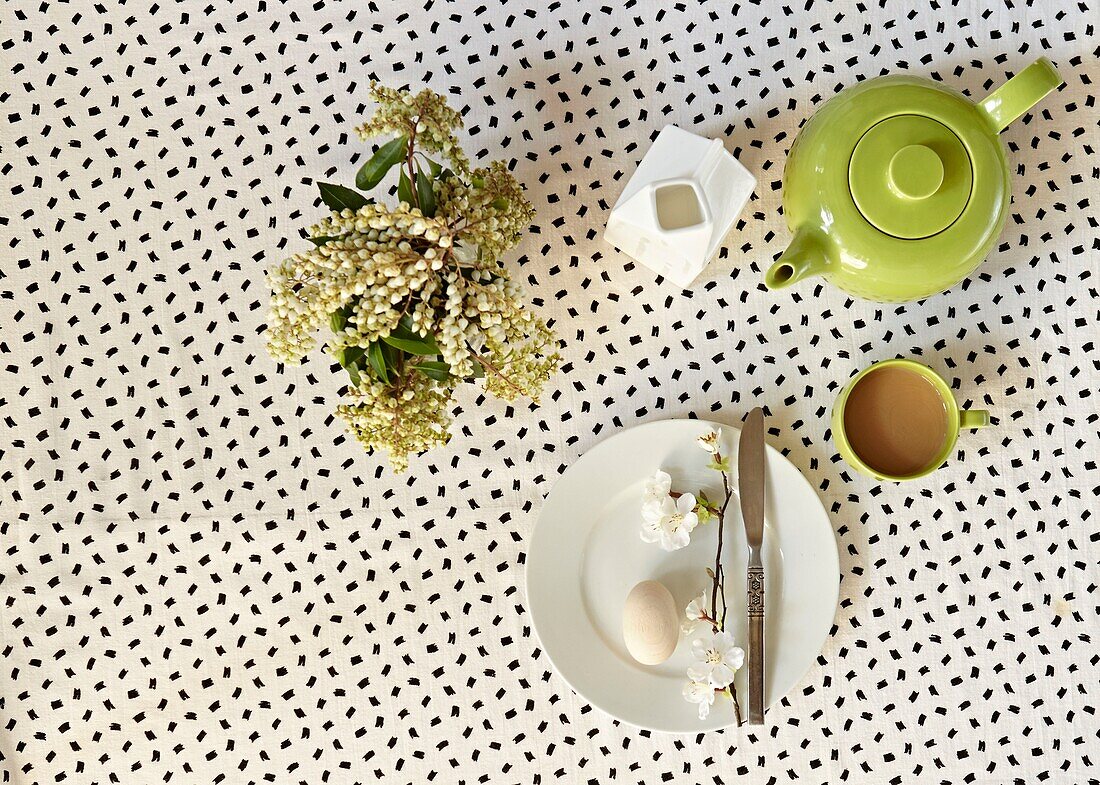 Cut spring flowers and tea with boiled egg on breakfast table in London home   England   UK