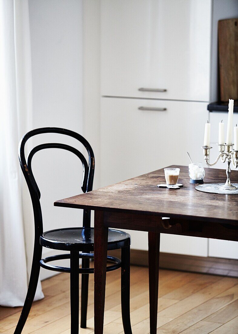 Holzstuhl und Tisch mit silbernem Kerzenhalter in einem modernen Londoner Haus England UK