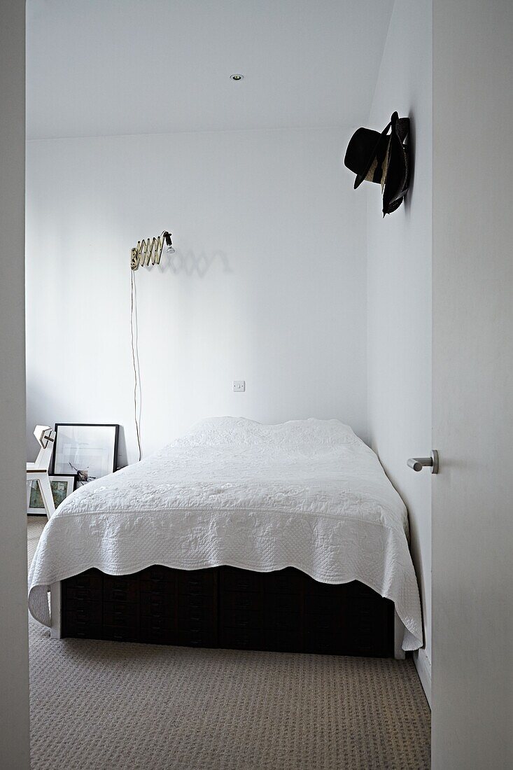 Blick durch die Tür zum weißen Doppelbett in einer modernen Londoner Wohnung England UK
