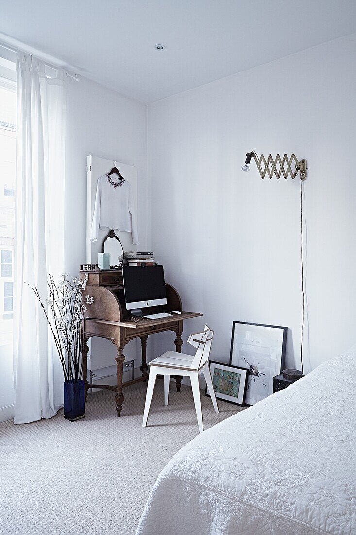 Holztisch und Stuhl in der Ecke des weißen Schlafzimmers in einem modernen Londoner Haus England UK