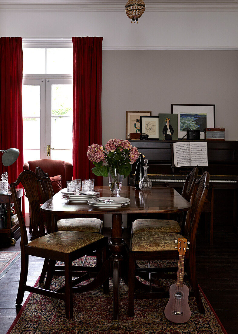 Polished wooden dining table and piano in contemporary London home   England   UK