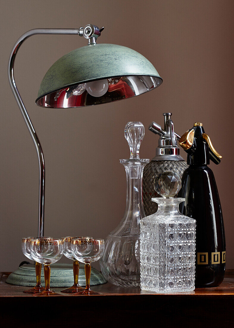 Soda bottles and decanter with vintage lamp in contemporary London home   England   UK