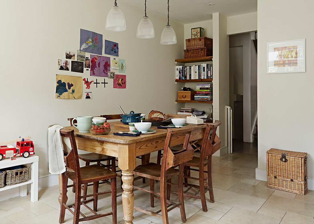 Wooden kitchen table with child's artwork in contemporary London family home   England   UK