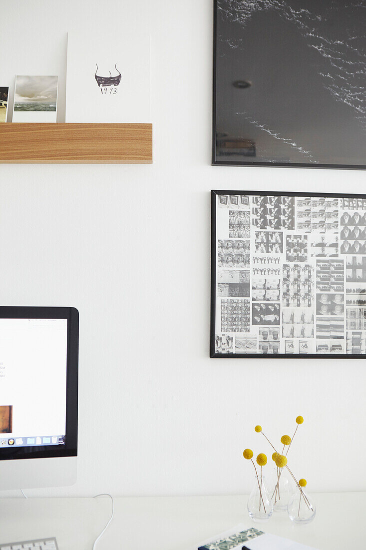 Framed artwork and postcards with computer screen in London home  UK
