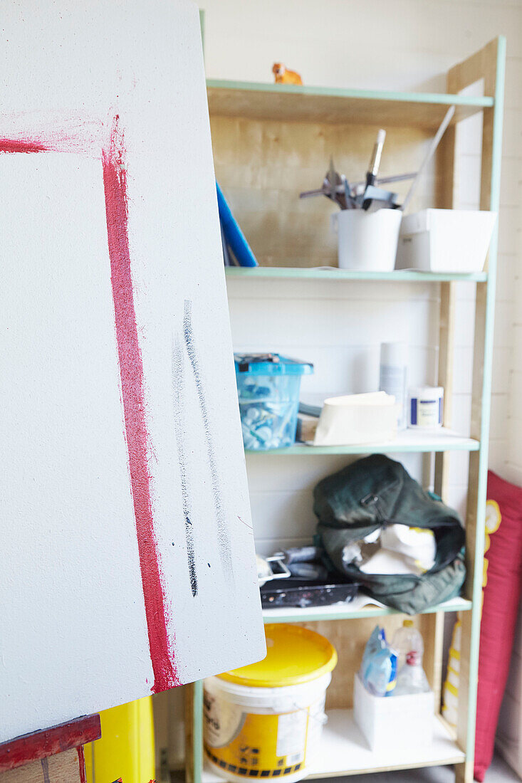 Kunstzubehör auf Regalen mit Leinwand auf Staffelei in einem Atelier in Alloa, Schottland UK