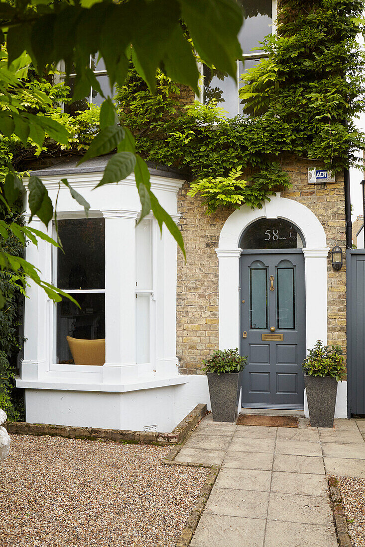 Haustür und Erkerfenster mit gepflastertem Fußweg und Kiesvorplatz Londoner Haus England UK