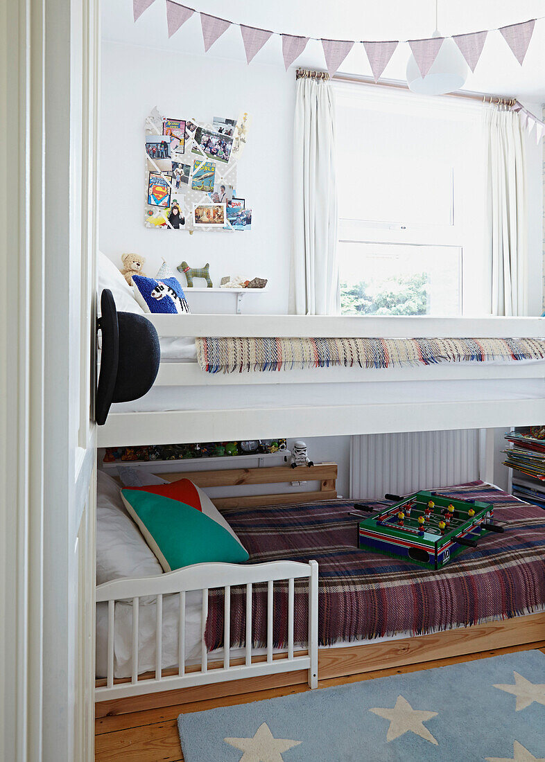 Etagenbett mit Decken und Pinnwand im Jungenzimmer eines Hauses in Faversham, Kent, UK