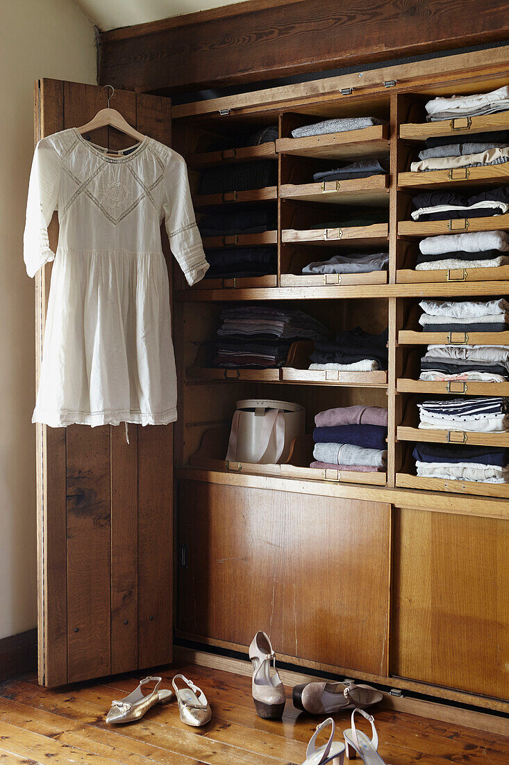 Gefaltete Kleidung mit hängendem Kleid in einem Kleiderschrank in West Yorkshire UK