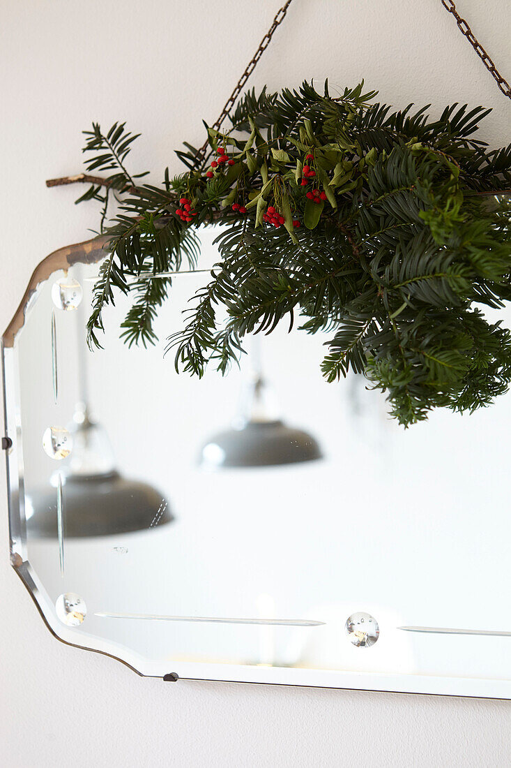 Holly berries and pine on vintage mirror in London home  UK