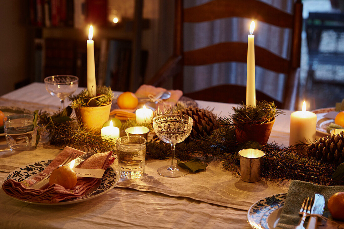 Beleuchtete Kerzen und Weingläser auf einem Esstisch in einem Londoner Haus UK