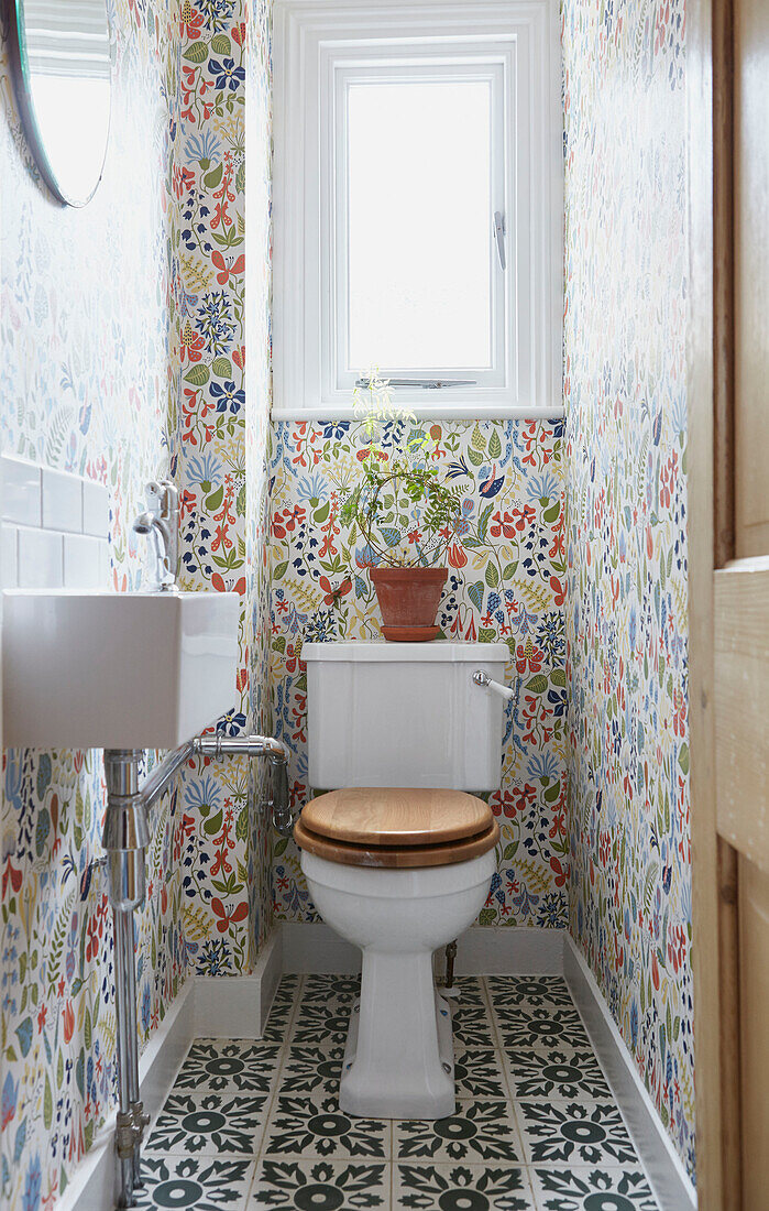 Floral gemusterte Tapete in einem kleinen Badezimmer in einer Londoner Wohnung UK
