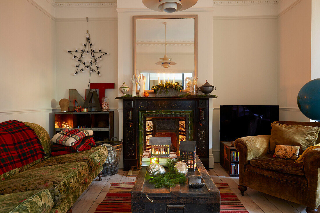 Sofa und Sessel mit großem Spiegel über dem viktorianischen Kamin im Wohnzimmer in Rochester Kent UK