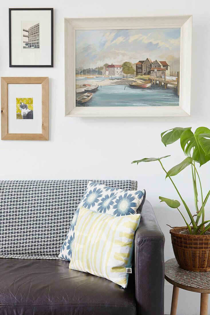 Zimmerpflanze und Kunstwerk mit schwarzem Ledersofa in einer Wohnung in Sheffield Yorkshire UK