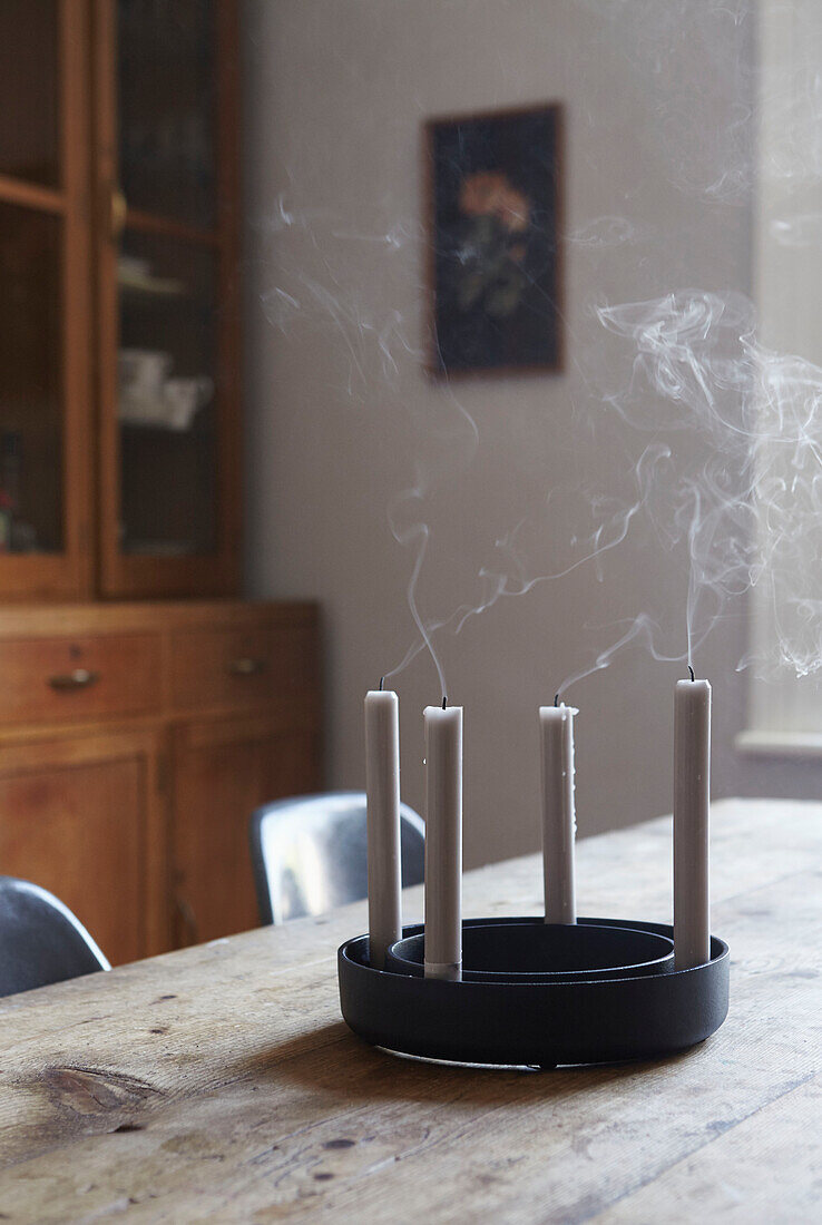 Abgeschnittene Kerzen mit Rauch auf einem hölzernen Esstisch in einem Haus in Sheffield Yorkshire UK
