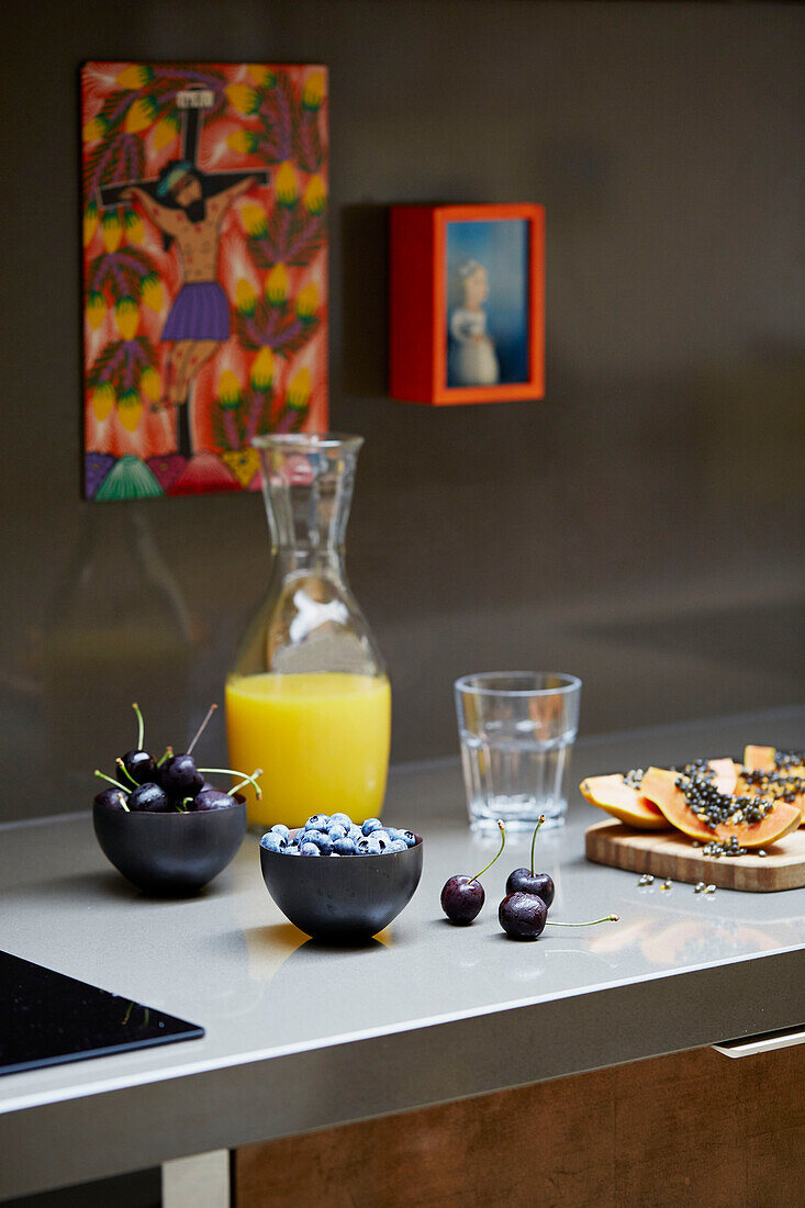 Früchte mit Orangensaft und Kunstwerk auf Küchenarbeitsplatte in East London Stadthaus England UK