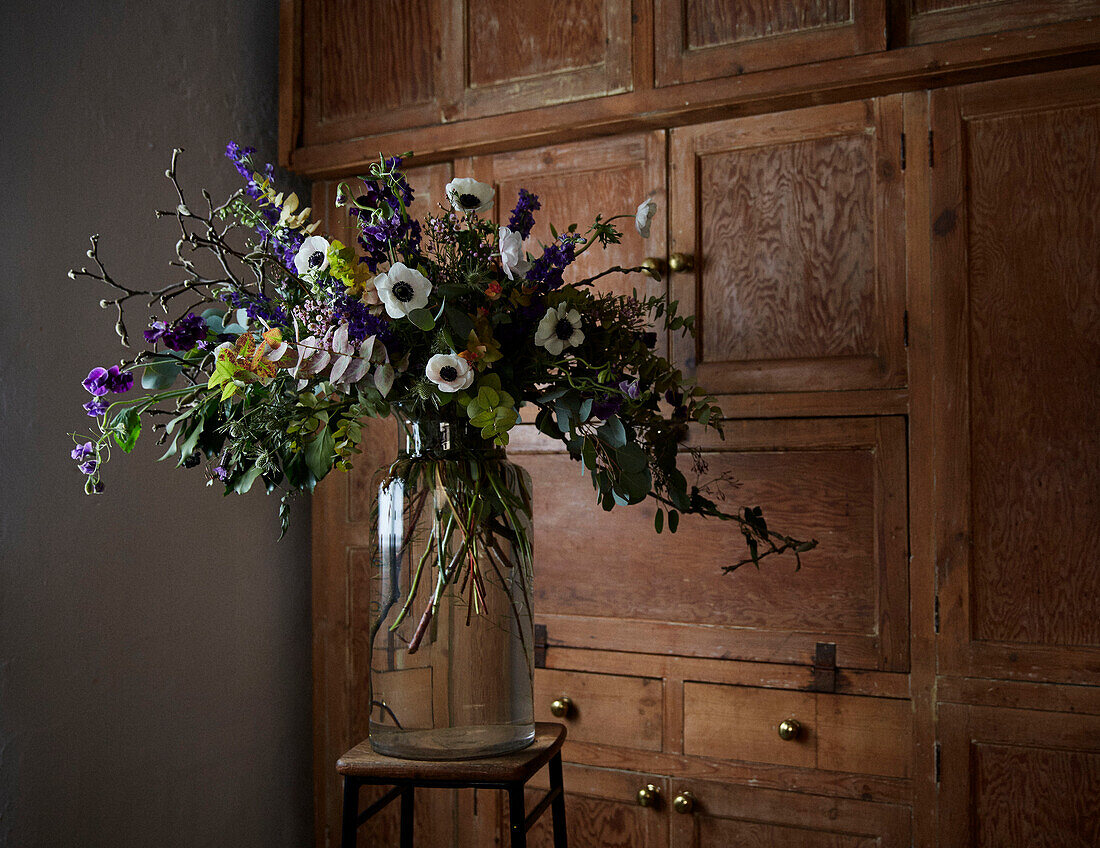 Vintage-Blumenarrangement mit Holzablage in einem Londoner Haus UK