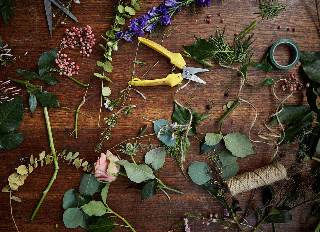 Verschiedene Blumenköpfe und Laub mit Gartenschere und Garn in einem Londoner Haus UK