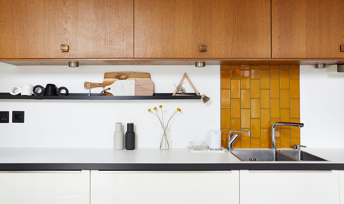 Contemporary kitchen with tiled mustard splashback in modernised Victorian home  Preston  Lancashire  England  UK