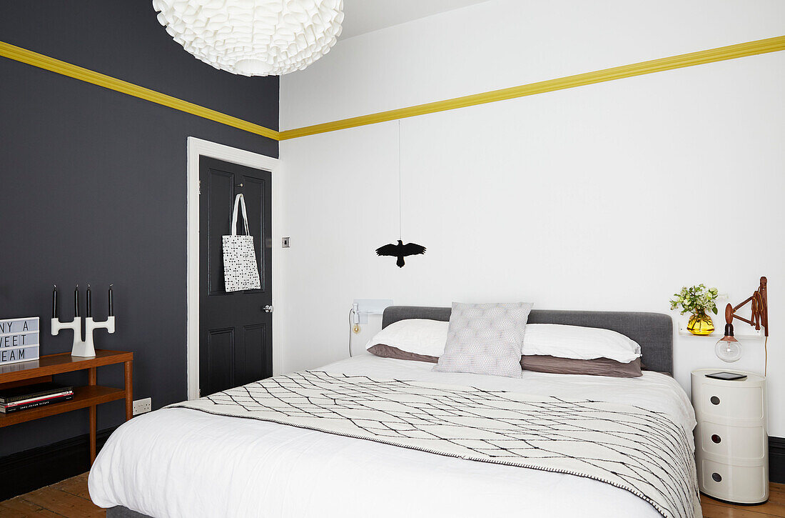Schlafzimmer in grau-gelb-weißer Farbkombination mit Normann Copenhagen-Anhänger in modernisiertem Haus in Preston, Lancashire, England UK