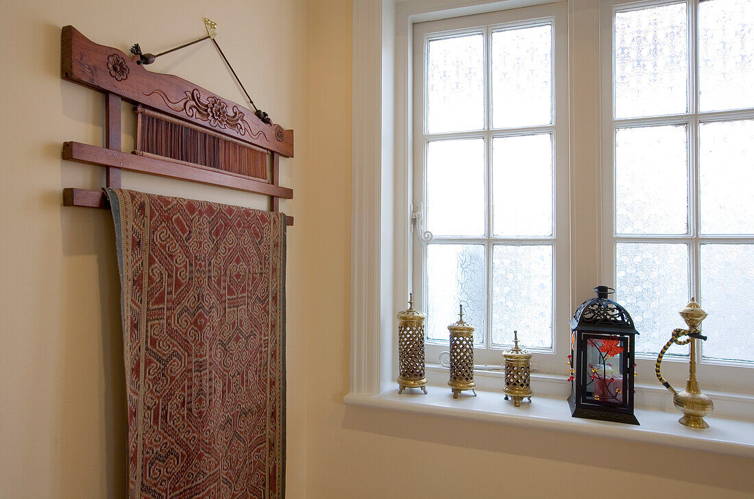 Tapestry wall hanging and lanterns at window of New Malden home, Surrey, England, UK