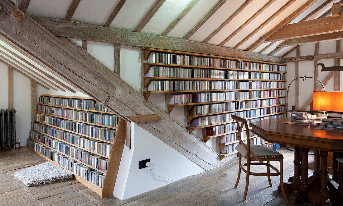 Bücher und CDs in einem Regal unter einer Balkendecke in einer umgebauten Wassermühle