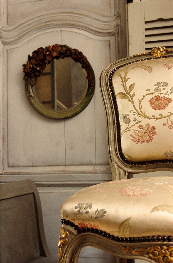 Stilleben mit französischem gepolstertem Fauteuil und dekorativem Spiegel
