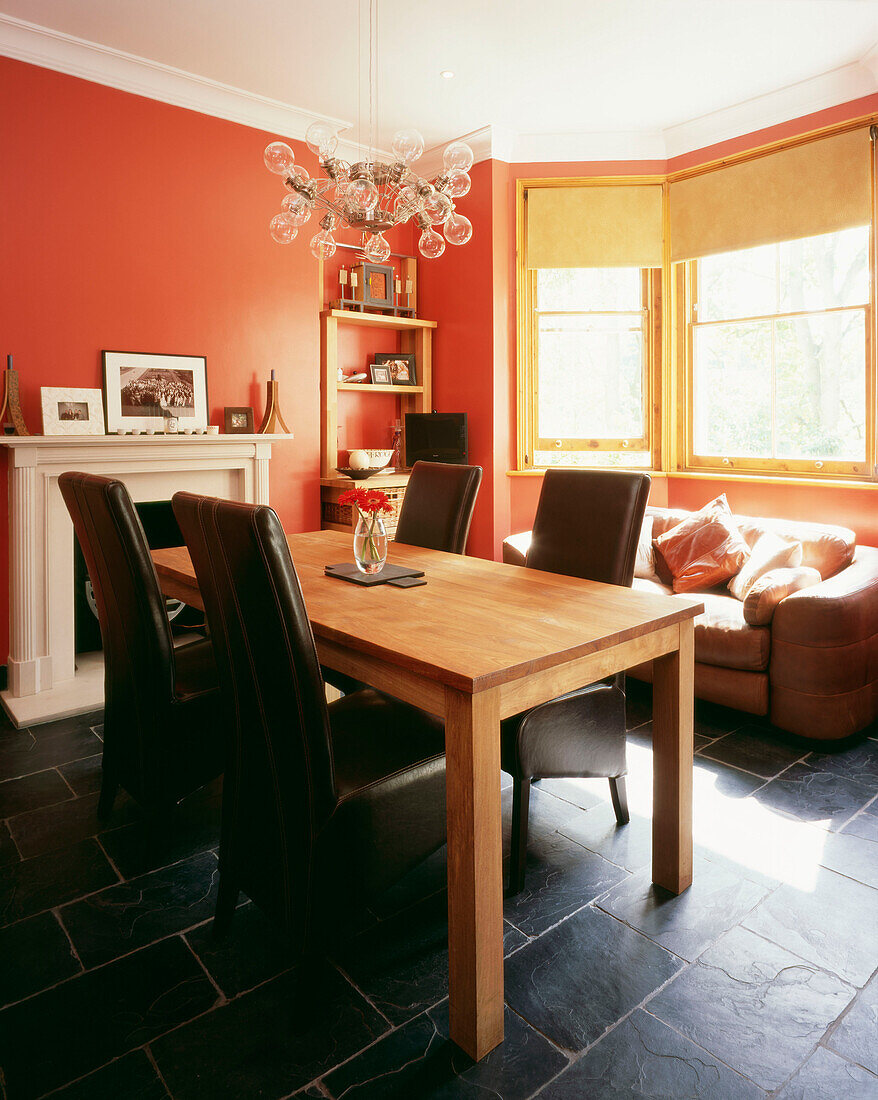 Esszimmer mit Lederstühlen mit hoher Lehne und Massivholztisch auf Schieferboden