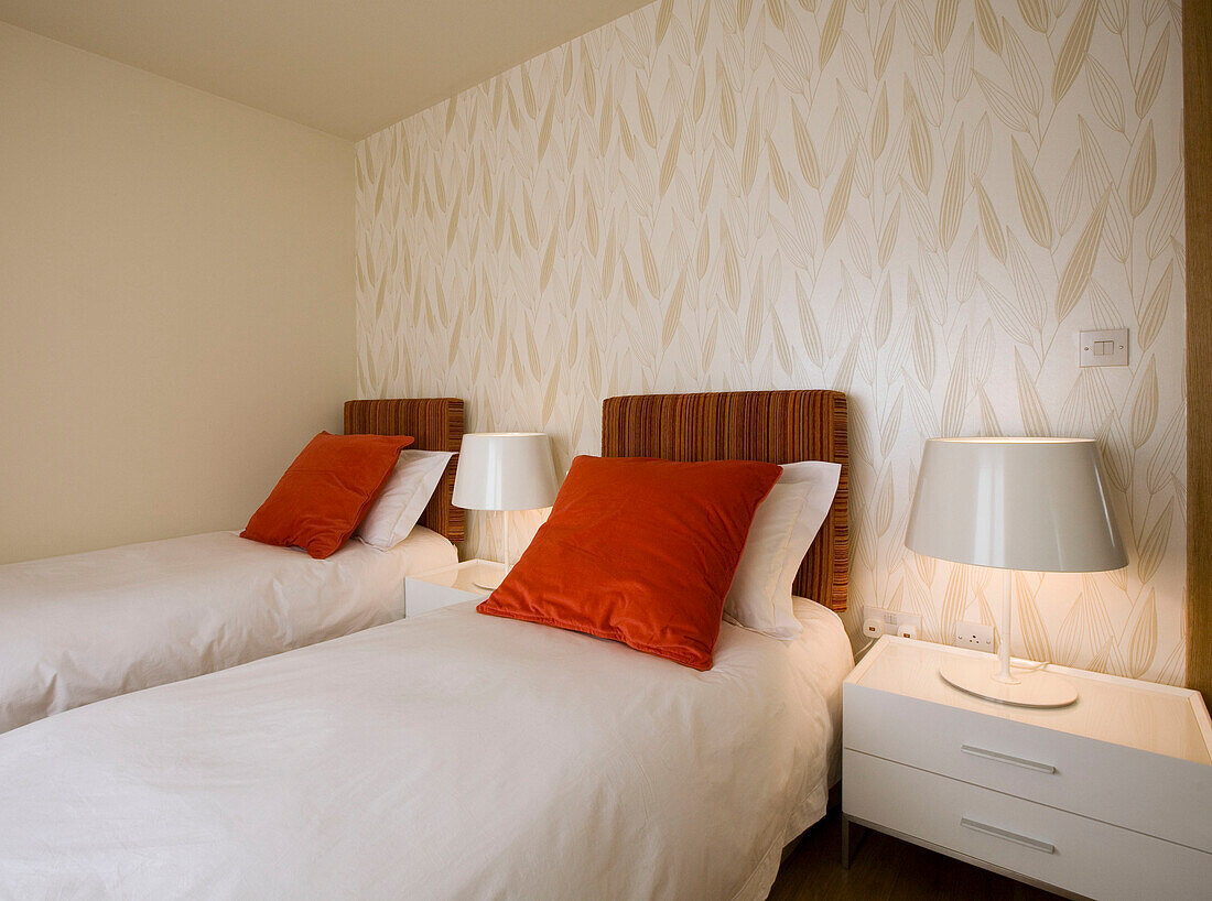 Neutrally decorated bedroom with wallpaper and bedside lamps