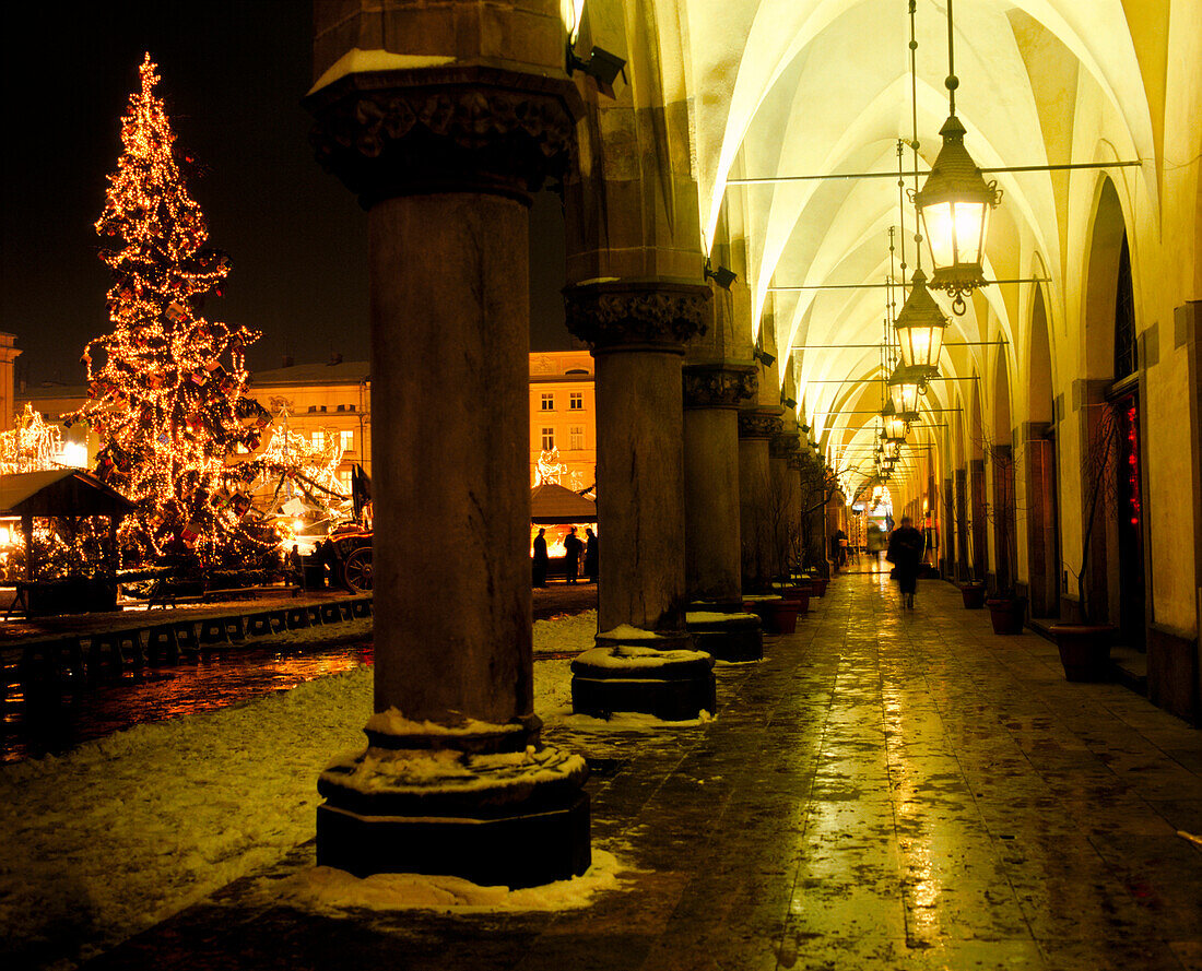 Beleuchteter Weihnachtsbaum auf dem Hauptplatz mit überdachtem Säulengang