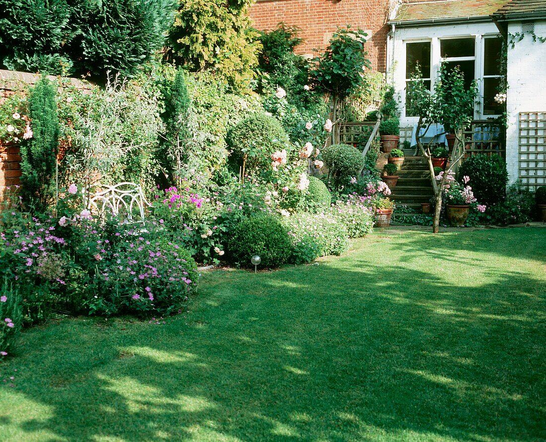 Häuslicher Garten mit Rasen und Blumenbeeten