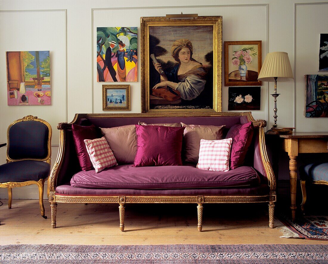 Lila gepolstertes Vintage-Sofa mit Kissen in einem holzgetäfelten Wohnzimmer