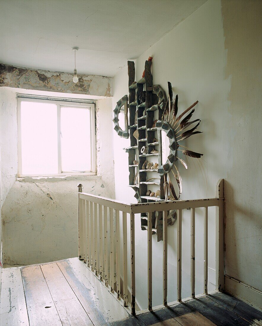 Totemisches Spiegelbild aus Treibholz im Treppenhaus