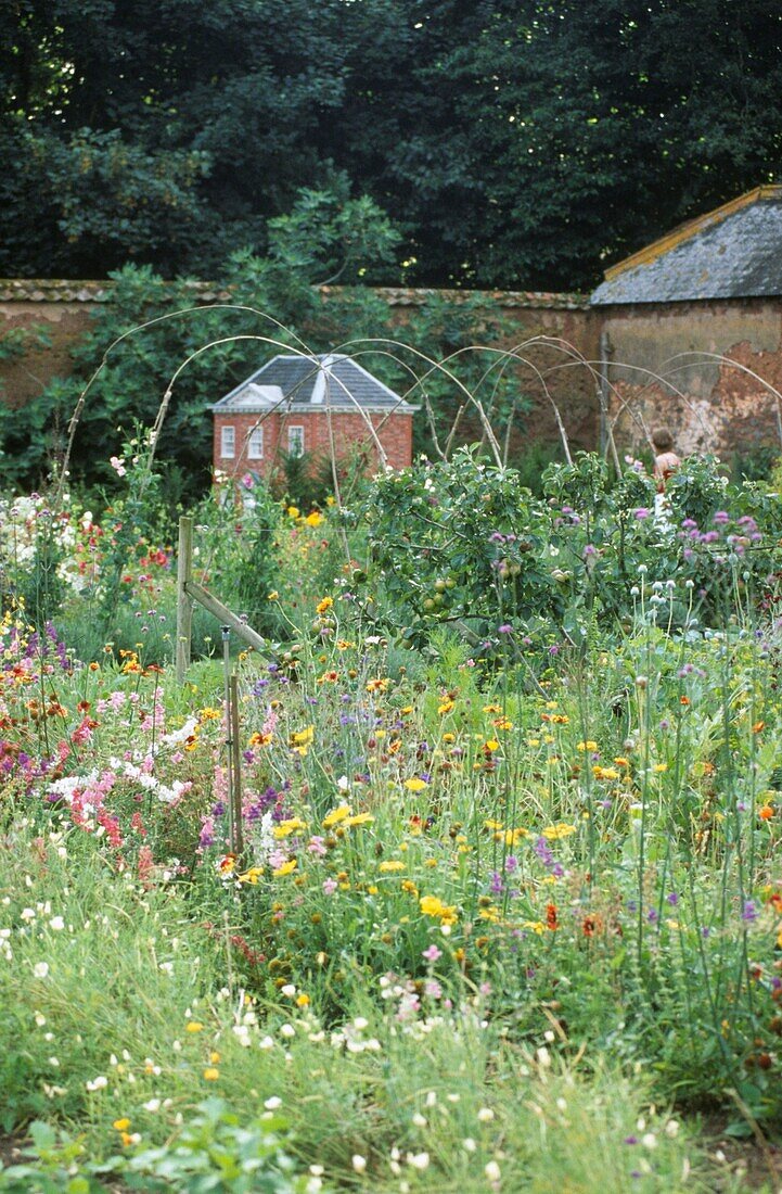 Miniature country house in walled flower garden