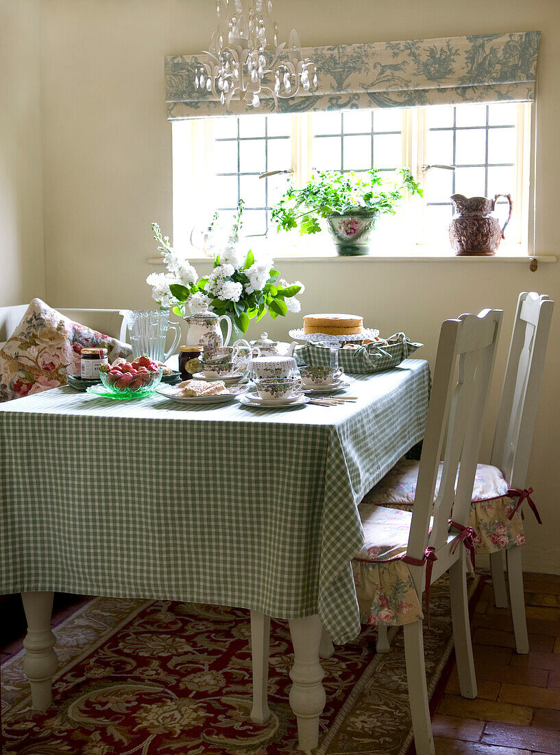 Kitchen table with green checked cloth set for afternoon tea