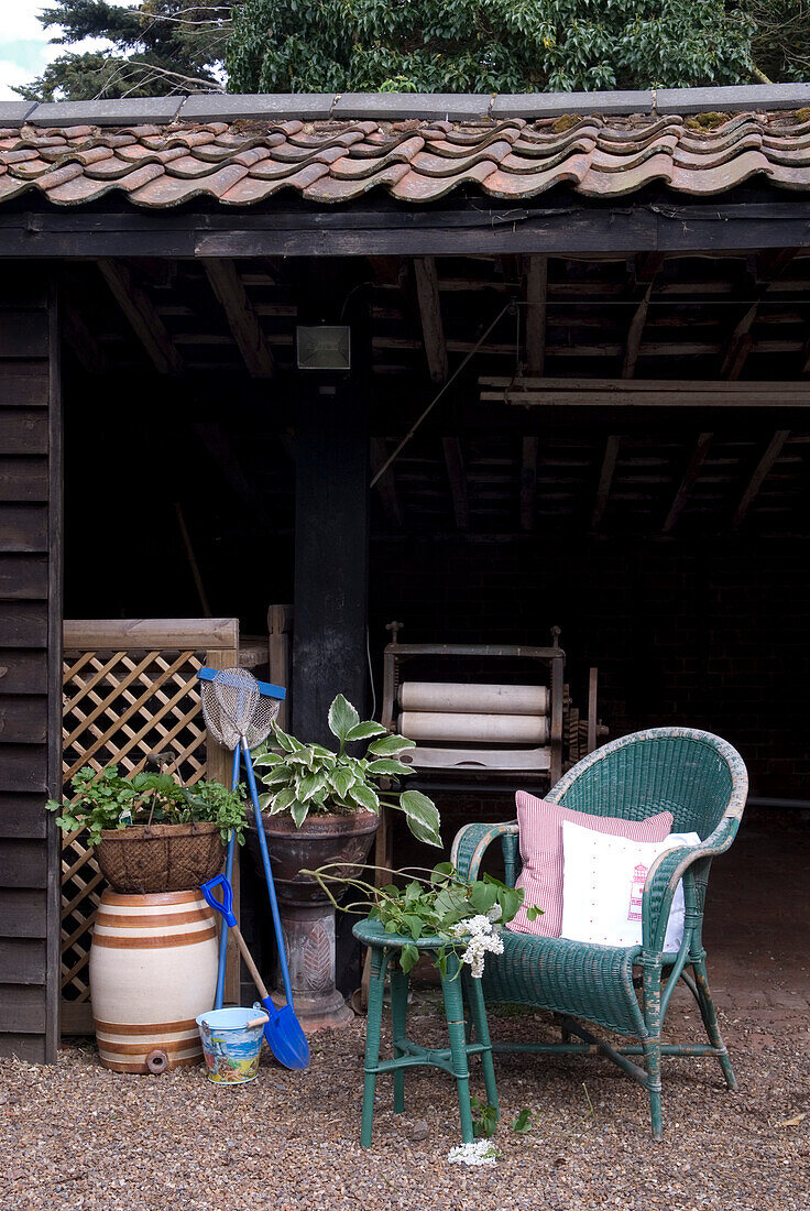 Wicker chair and fishing nets with mangle in rural outhouse