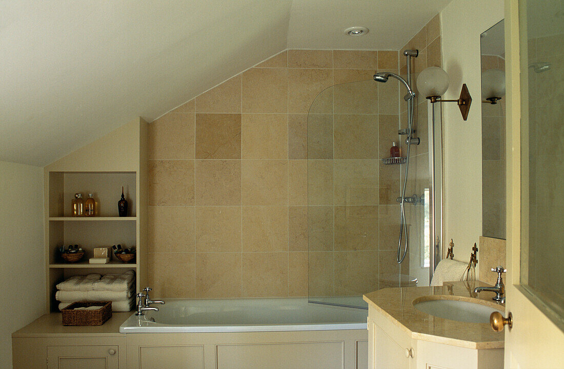 Neutral bathroom in coach house renovation with fitted shelving shower and screen 