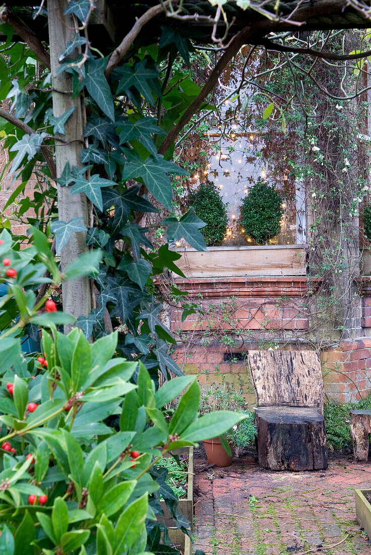 Blick durch die Pergola zum Erkerfenster mit Weihnachtsbaumbeleuchtung