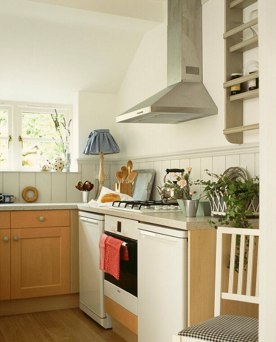 Backofen und Dunstabzug in einer Küche mit gekalkten Eichenschränken und einer Arbeitsplatte aus Granitlaminat