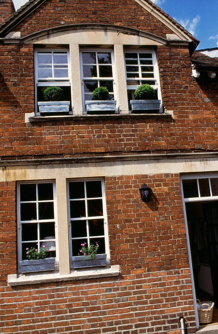 Brickwork facade of Oxfordshire house window boxes on narrow sash windows