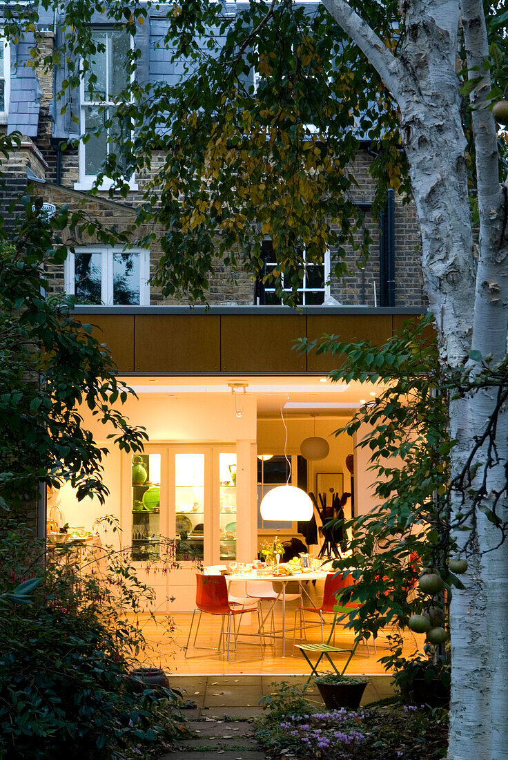 Lit kitchen extension with dining table and chairs