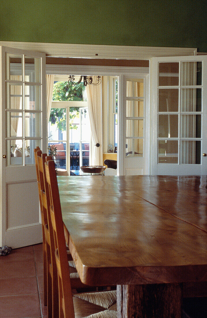 Polierter hölzerner Esszimmertisch mit Doppeltüren, die sich zum Wohnzimmer hin öffnen
